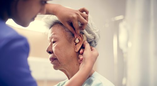 An elderly woman with hearing aid